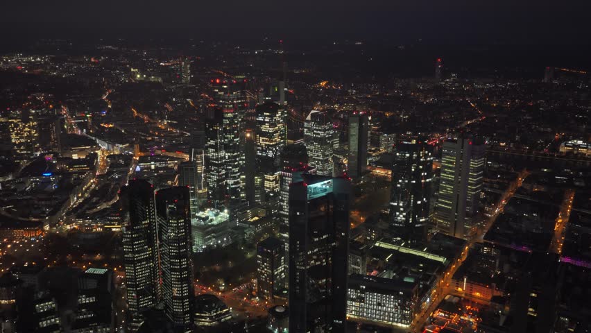 Frankfurt skyline glowing at night with an aerial view of financial district. Modern architecture and skyscrapers like Trianon illuminate city