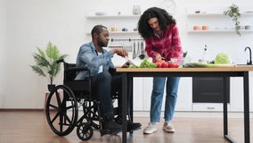 A diverse couple prepares a meal together in a bright, modern kitchen, with one person using a wheelchair. - Powered by Shutterstock - Get 15% off with code: PIKWIZARD15