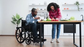A diverse couple enjoys cooking together in a bright, modern kitchen, with one person using a wheelchair. - Powered by Shutterstock - Get 15% off with code: PIKWIZARD15