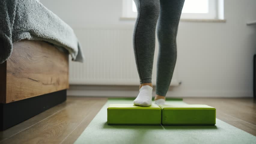 Girl Performs Step-Ups On A Yoga Mat At Home For Conditioning Of Foot And Calf Muscles