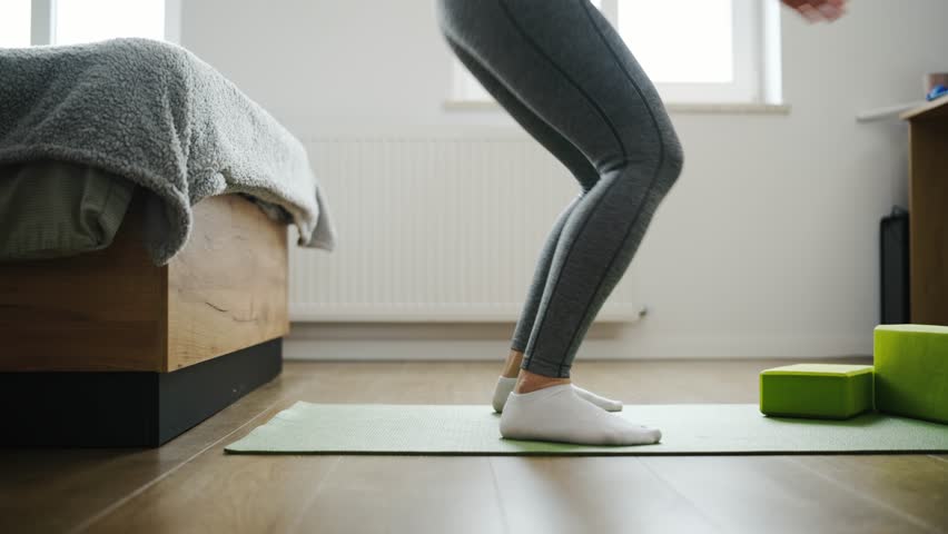 Girl Doing Deep Squats At Home On A Yoga Mat As Daily Routine