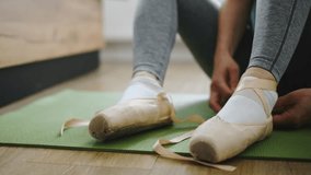 Girl Sitting On The Floor Ties Ribbons Of Ballet Pointe Shoes At A Dance Rehearsal - Powered by Shutterstock - Get 15% off with code: PIKWIZARD15