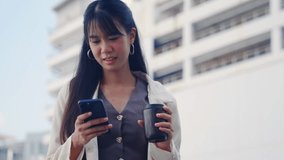 Young happy business businesswoman outdoor walking through modern office district, smiling while using smartphone for communication, holding coffee cup, contemporary urban cityscape background. - Powered by Shutterstock - Get 15% off with code: PIKWIZARD15