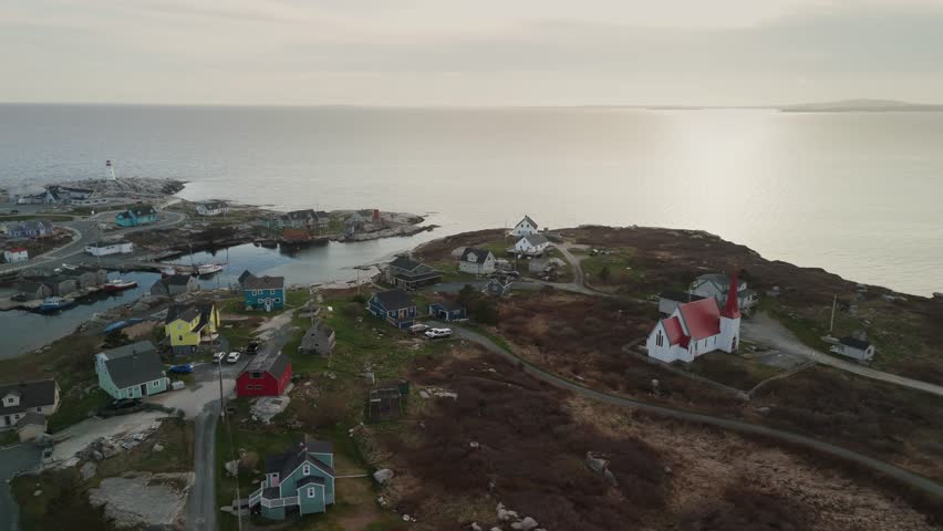 Aerial View Of Peggys Cove Near Halifax, Nova Scotia, Featuring A Serene Fishing Harbor With Lobster Boats, Traditional Coastal Homes, Narrow Wooden Wharves, And The Iconic Lighthouse Set On Rugged 