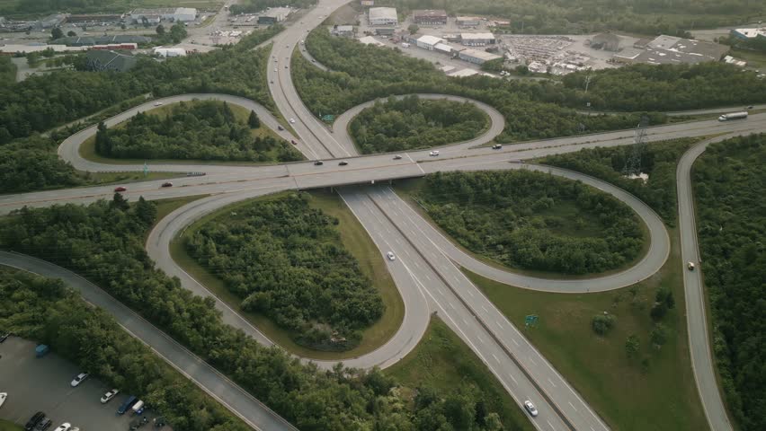 Aerial View Showing Vehicles Driving Through A Highway Network In Dartmouth Nova Scotia Canada With Traffic Flowing Across The Bridge Into Halifax Under Warm Daylight And Clear Urban Skies