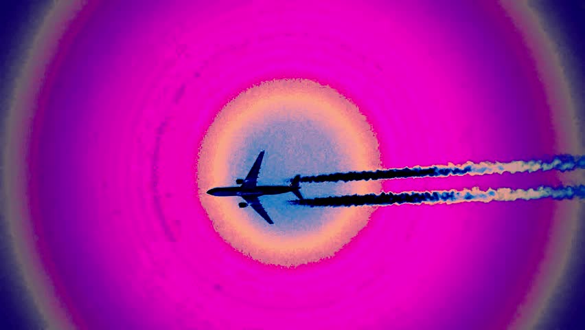 Handheld video with over 120× combined zoom shows a passenger airplane flying against a dramatic sky with contrails and colorful circular light effects, giving an animated look, 2019