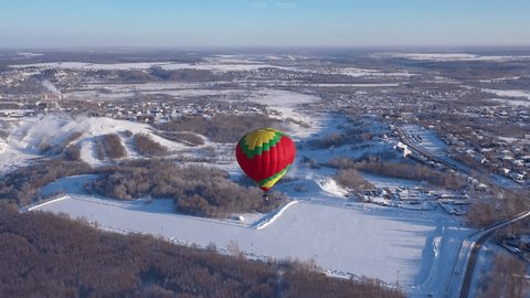 Descending Drone Tracking Balloon above Winter Village