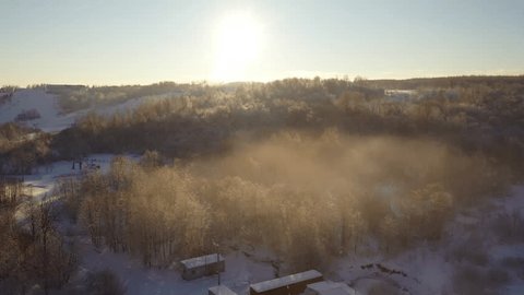 Drone Gliding Upward Left over Snowy Woodland