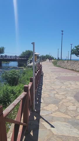 River flow with footbridge and green vegetation on bright sunny day creating natural summer atmosphere, Antalya, Turkey, taken handheld. High quality FullHD footage