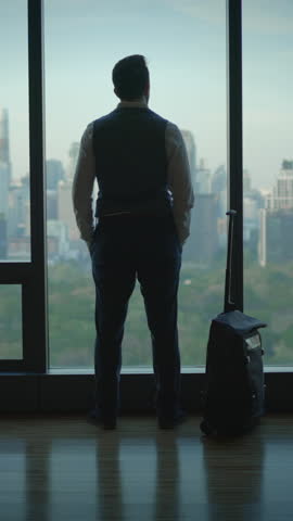 person watches cityscape patiently, man remains composed while overlooking busy city view from afar