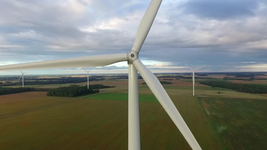 Windmills in Beautiful Nature, Landcape. Sustainable power. Aerial view of wind turbines. Alternative Eco Energy Wind Turbine in Beautiful Green Landscape at Sunset. Aerial drone view