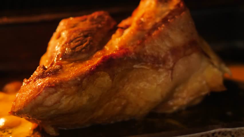 close-up of a piece of meat frying on a baking sheet in the oven, appetizing piece of meat being cooked in the kitchen, meat delicacies preparation