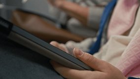 Side view closeup shot of young girl holding digital tablet in hands and playing games while waiting for doctors appointment in clinic waiting room, with focus flowing from hands to face, copy space - Powered by Shutterstock - Get 15% off with code: PIKWIZARD15
