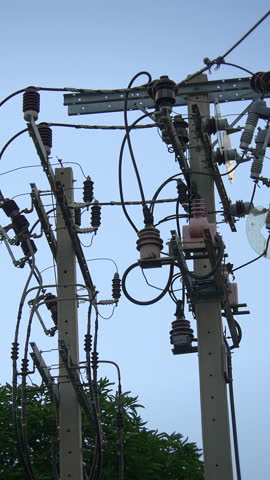 industrial power distribution setup with technicians inspecting cables and insulators in daylight