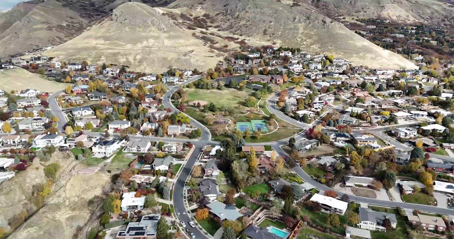 4K footage of a suburban neighborhood surrounded by vibrant autumn foliage. Perfect for real estate projects, seasonal content, travel videos, lifestyle media, or scenic cinematic footage. 