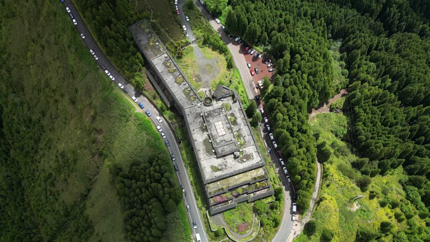 Aerial shot of the abandoned hotel sitting above lush green hills. Great for documentaries, mystery themes, or travel storytelling.