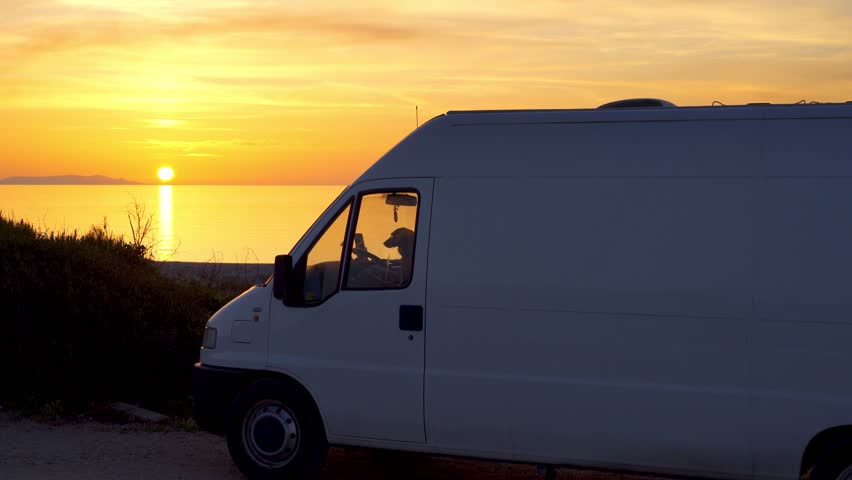 Camper van at sunset on a beach in Sardinia, Italy