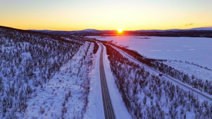 Sunset over arctic landscape in Lapland, Sweden, road and railroad between Kiruna and Narvik