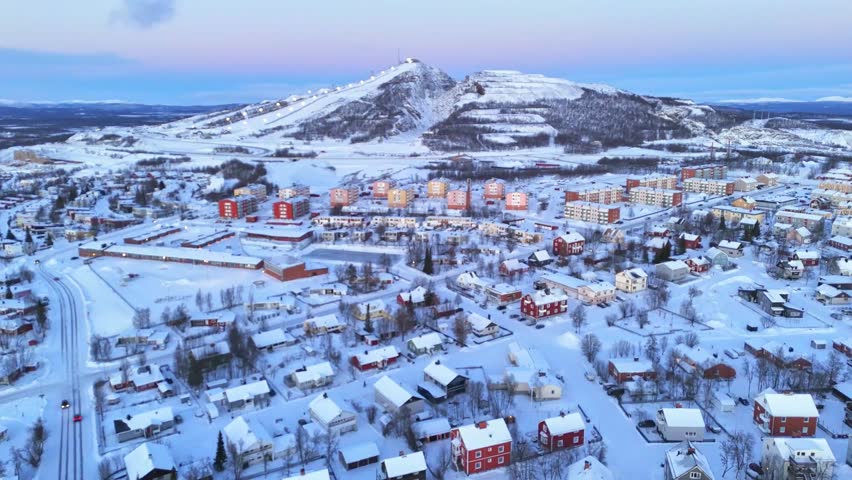 Kiruna, Lapland, Sweden, beautiful aerial view of the colorful houses and of the hill with ski slopes, during the arctic winter and polar night