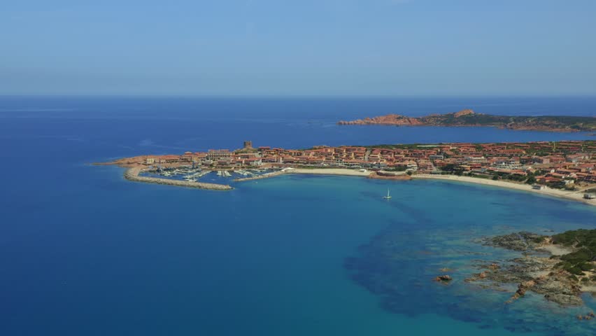 Aerial drone view of Castelsardo and Isola Rossa seaside town with a marina along the azure coastline of Sardinia, Italy