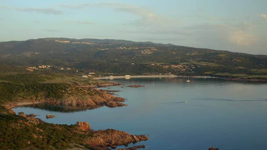Drone aerial view of Punta Canneddi red rock landscape in Isola Rossa beach region of Sardinia, Italy at sunset