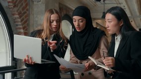 Concentrated work process in office three multiracial business workers team women girls females businesswomen talking about job document Muslim Asian Caucasian ladies discuss laptop project meeting - Powered by Shutterstock - Get 15% off with code: PIKWIZARD15