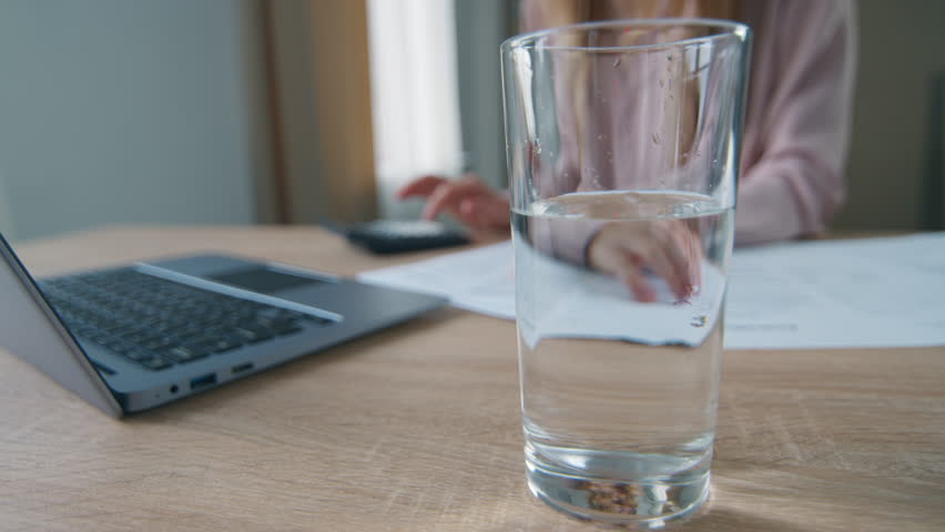 Unrecognizable business woman working laptop in office put pill in glass of water businesswoman female girl calculating finance throwing painkiller pill in drink bubbles sizzling medicine health care