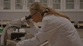 Lab scientist peering into microscope and adjusting knobs while math notes appearing, showing data. Researcher, laboratory, eyepiece, apparatus, annotation, analysis, optics - Powered by Shutterstock - Get 15% off with code: PIKWIZARD15