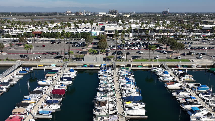 Long Beach, California, USA - Aerial View of 2nd and PCH Shopping Center With Naples Island Boats and Yachts With Refineries and Mountains in the Back Going Left to Right in the Marina Pacifica