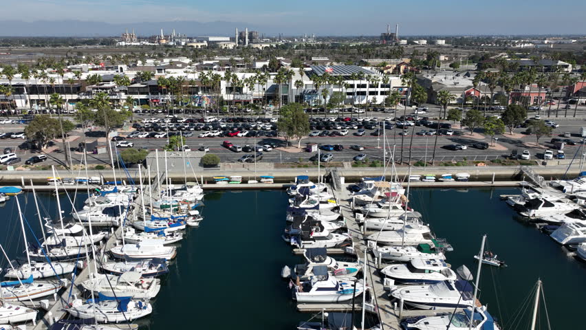 Long Beach, California, USA - Aerial View of 2nd and PCH Shopping Center With Naples Island Boats and Yachts With Refineries and Snowy Mountains in the Back Going Right to Left in the Marina Pacifica