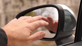 Man's Hand Gently Touching Car Side Mirror, Close Up - Powered by Shutterstock - Get 15% off with code: PIKWIZARD15