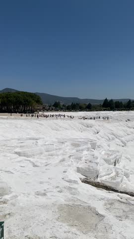 Pamukkale, the cotton castle and cotton hill, white travertine natural hot spring and ancient Roman Greek bath house at Hierapolis ruins site, Turkiye 