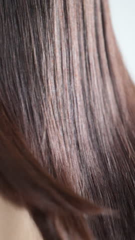 Close-up video of glossy, long black hair with beautiful, cuticle-smooth straight strands—evoking hair care imagery	