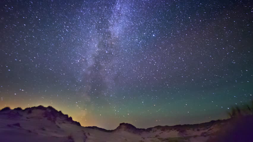 Night sky with satellites and Milky way over a desert landscape with sand dunes, SIMULATION OVER ORIGINAL TIMELAPSE FOOTAGE.