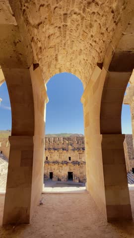 Aerial view showing ancient Roman amphitheater at Aspendos with tiered stone seating and scenic mountain backdrop, ideal for Social Media history content and cultural travel scenes.