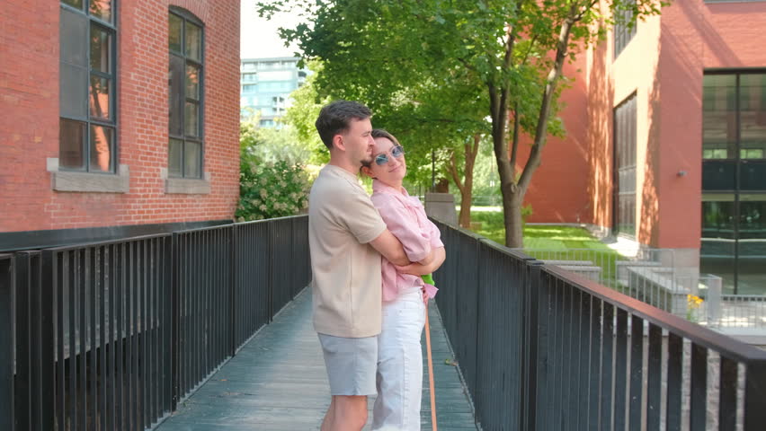 Romantic couple hugging on bridge by brick building