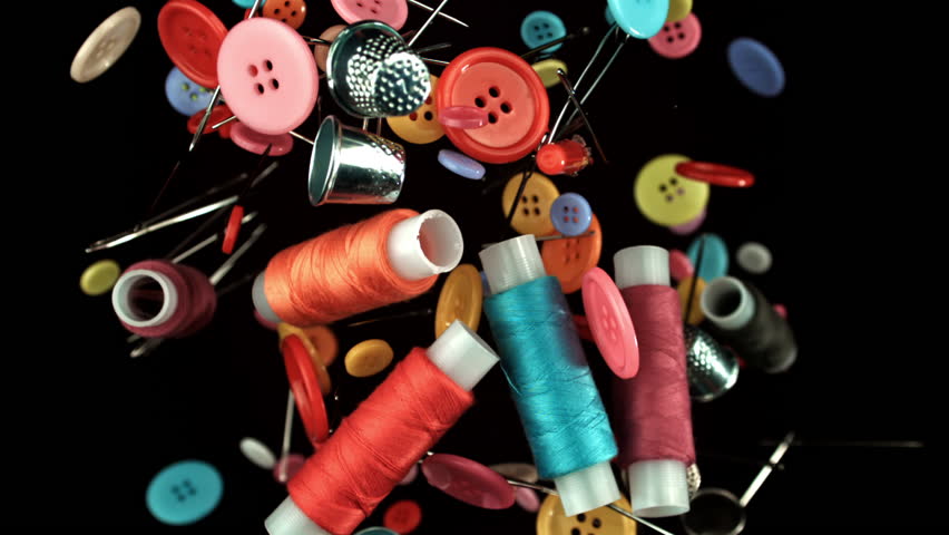 Various sewing accessories fly on a black background. Filmed on a high-speed camera at 1000 fps. High quality FullHD footage