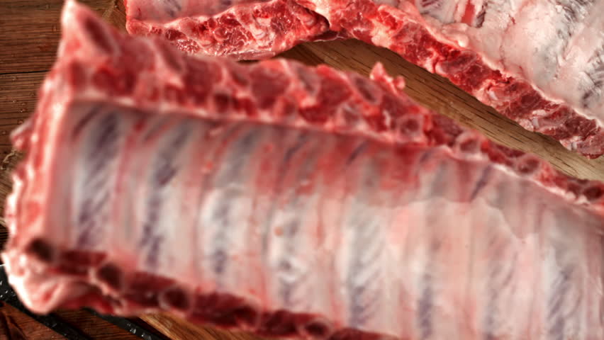 Raw pork ribs fall onto a cutting board. Filmed on a high-speed camera at 1000 fps. High quality FullHD footage