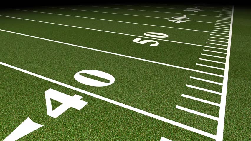 A low-angle perspective of an American football field, showcasing yard lines and numbers on the green turf.