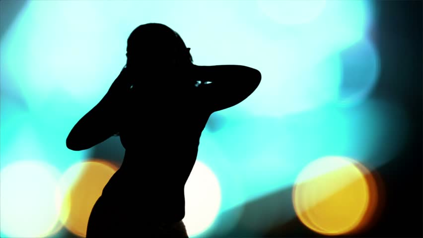 A silhouette of a dancer is set against a backdrop of vibrant bokeh lights, creating a dynamic and energetic nightlife scene.