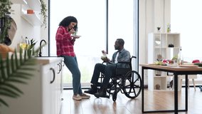 A diverse couple shares a meal together in a bright, modern kitchen setting. One person is in a wheelchair. - Powered by Shutterstock - Get 15% off with code: PIKWIZARD15