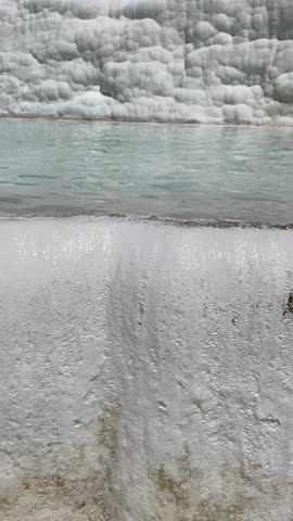 Pamukkale, the cotton castle and cotton hill, white travertine natural hot spring and ancient Roman Greek bath house at Hierapolis ruins site, Izmir, Turkiye 