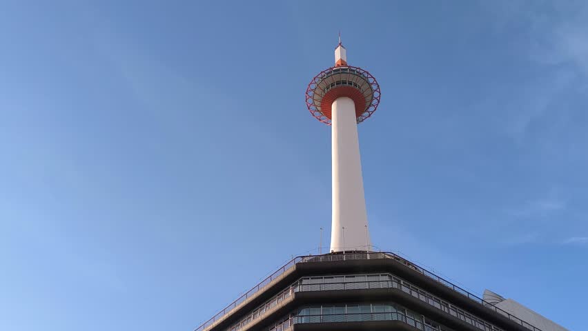 Low angle establishing of Kyoto Tower, central landmark in Japanese City, blue skyline background