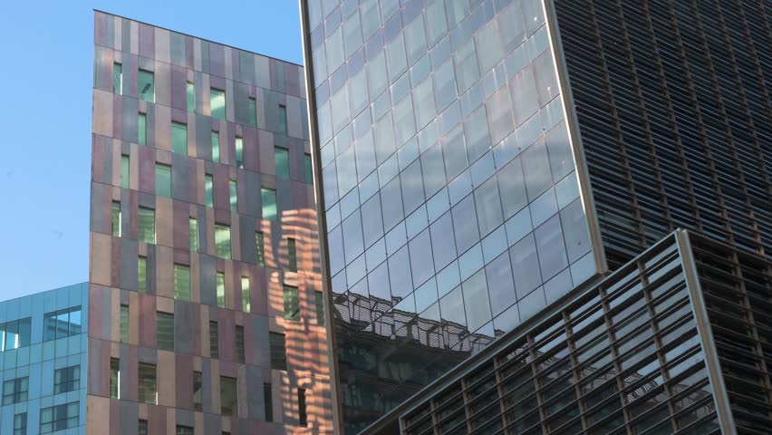 Abstract view of contemporary buildings in Barcelona, Spain. Contrasting blue and red facades reflect the light, showcasing the dynamic expression of modern Spanish architecture.