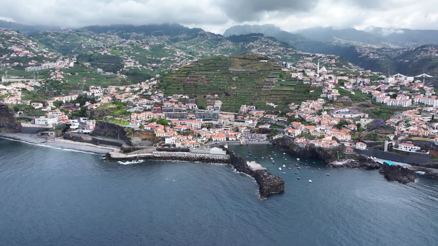 Câmara de Lobos fishing port and coastline with buildings on hillsides, aerial