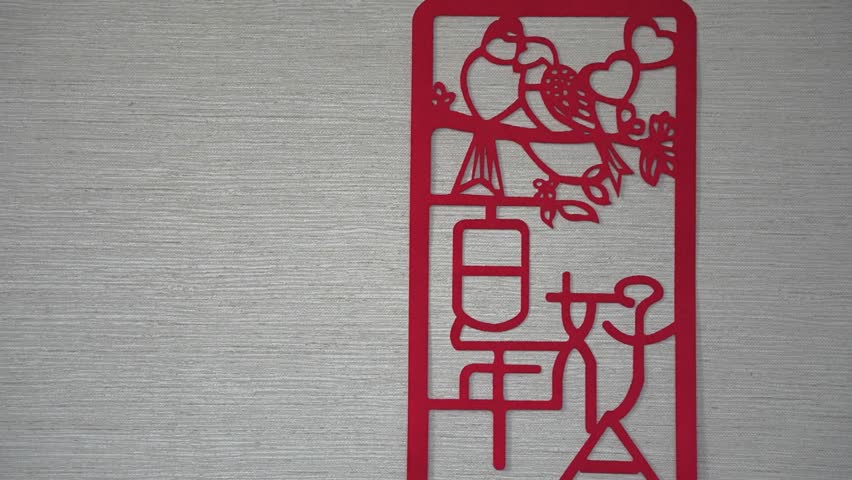 Chinese wedding paper-cut on textured wall.