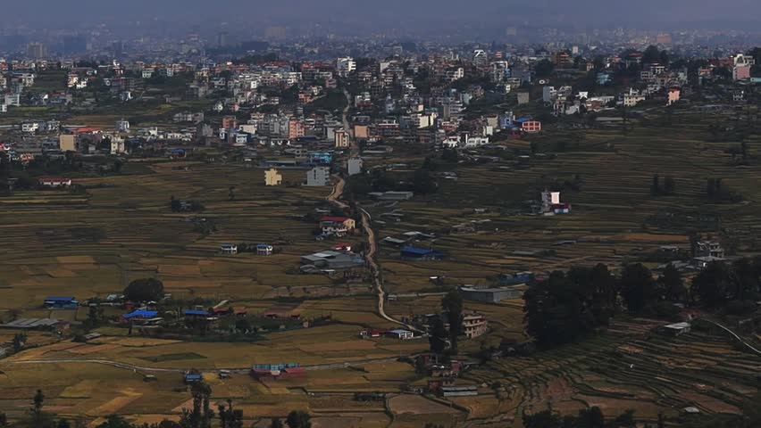 Kathmandu city and valley hills viewed from above featuring urban landscape, green slopes, hazy sky,Himalayas and wide aerial scenery representing Nepal environment and mountain region landform spot