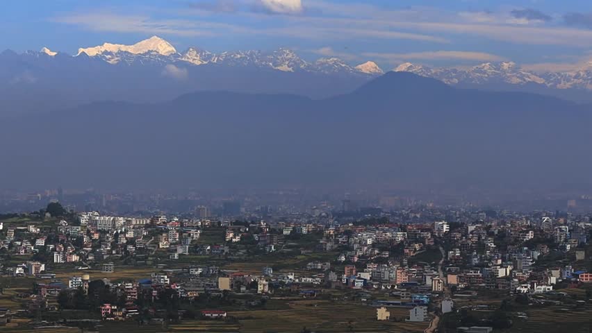 Kathmandu city and valley hills viewed from above featuring urban landscape, green slopes, hazy sky,Himalayas and wide aerial scenery representing Nepal environment and mountain region landform spot
