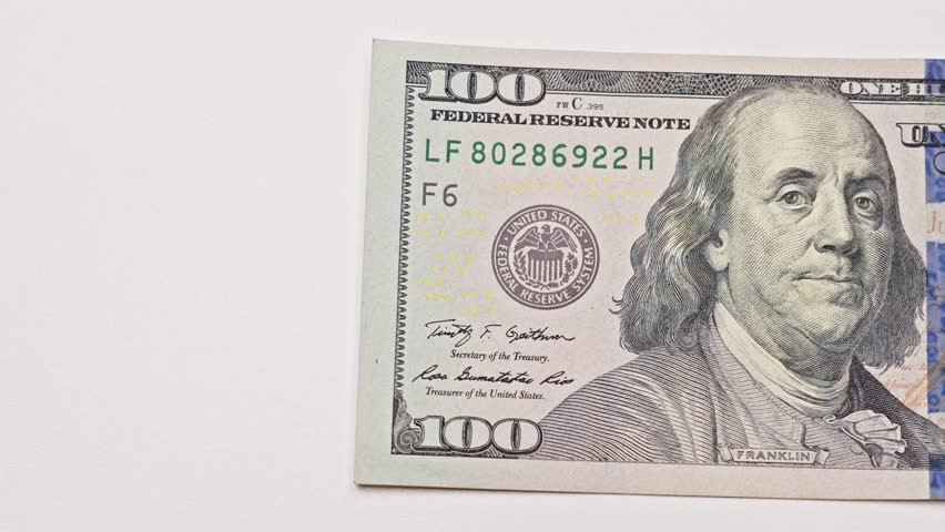Stack of US hundred dollar bills being counted on a light table with copy space, illustrating cash pile, financial calculations, cash flow, and banking concepts.