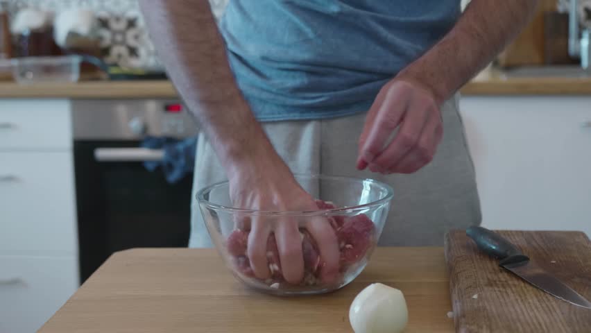 Mixing Chopped Onion into Raw Meat for a Marinade, Man Preparing Meal